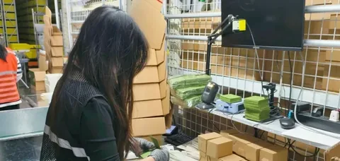 Worker checking parcels at a China dispatch workstation